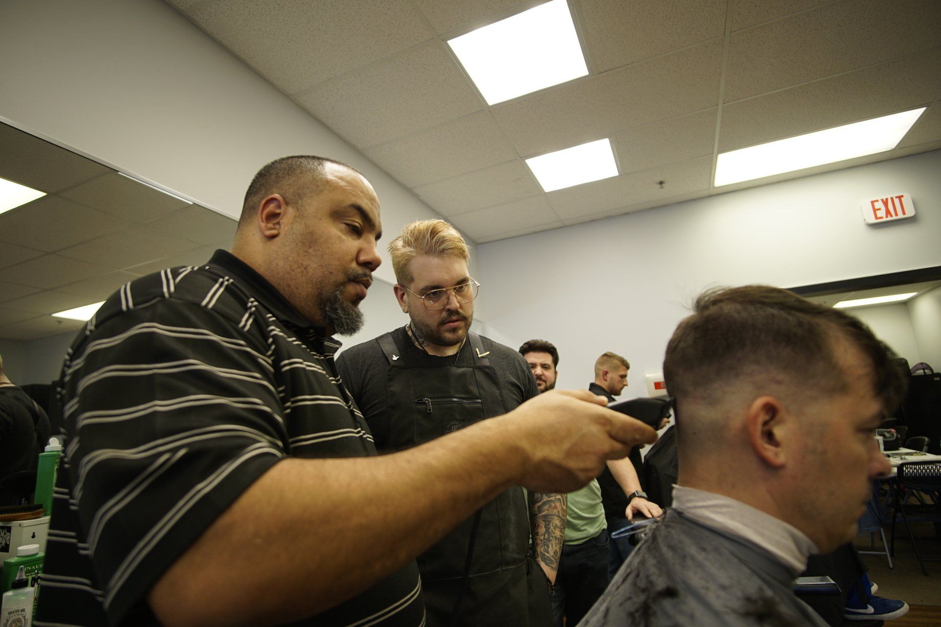 A man is getting his hair cut by a barber in a barber shop.
