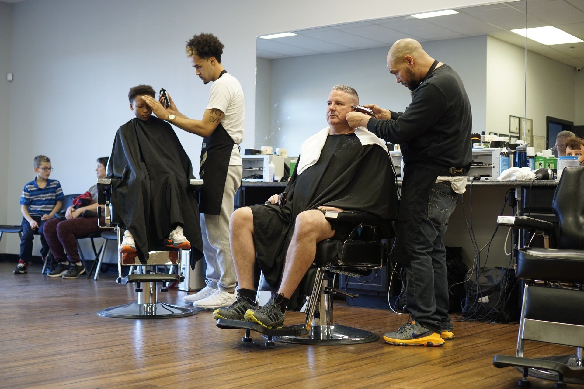 A man is getting his hair cut at a barber shop.