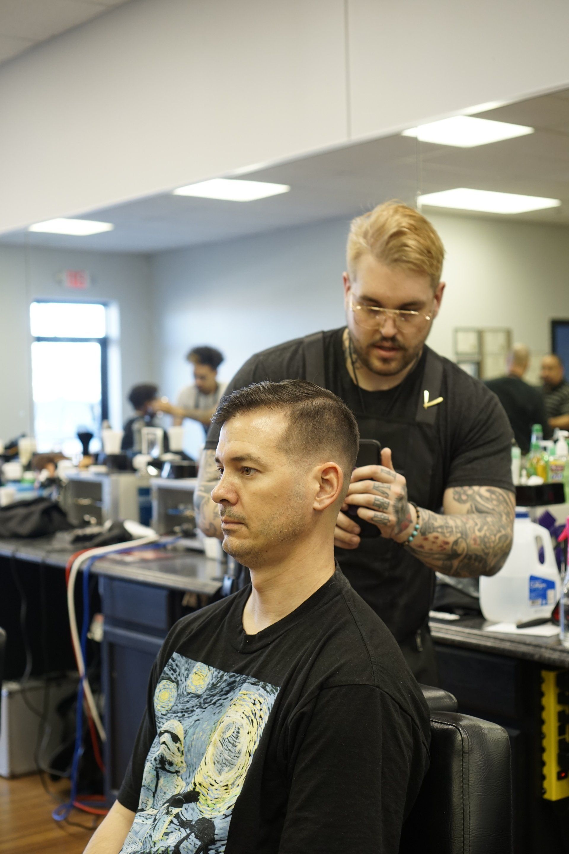 A man is getting his hair cut by a barber in a barber shop.