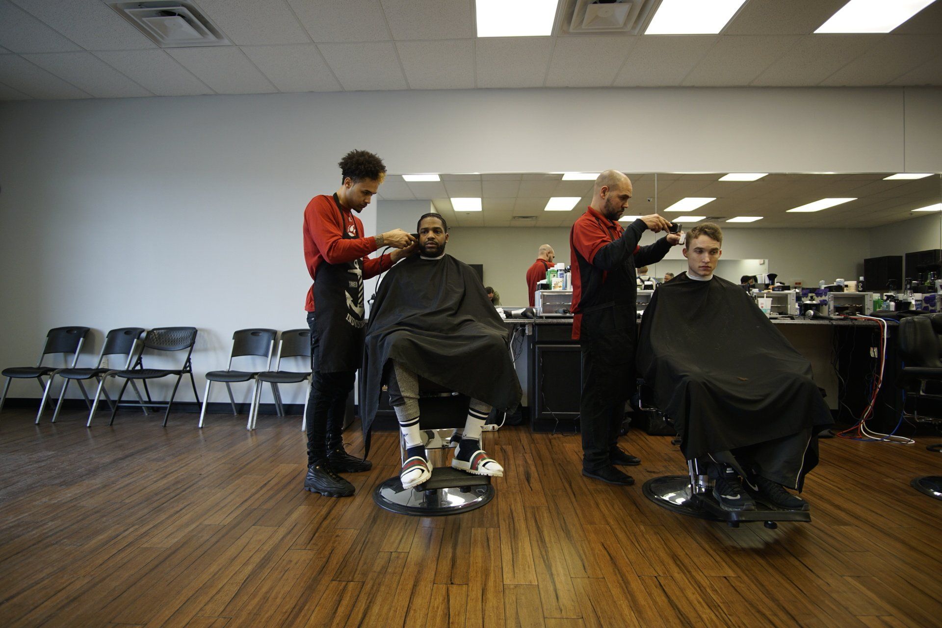 A man is getting his hair cut at a barber shop.