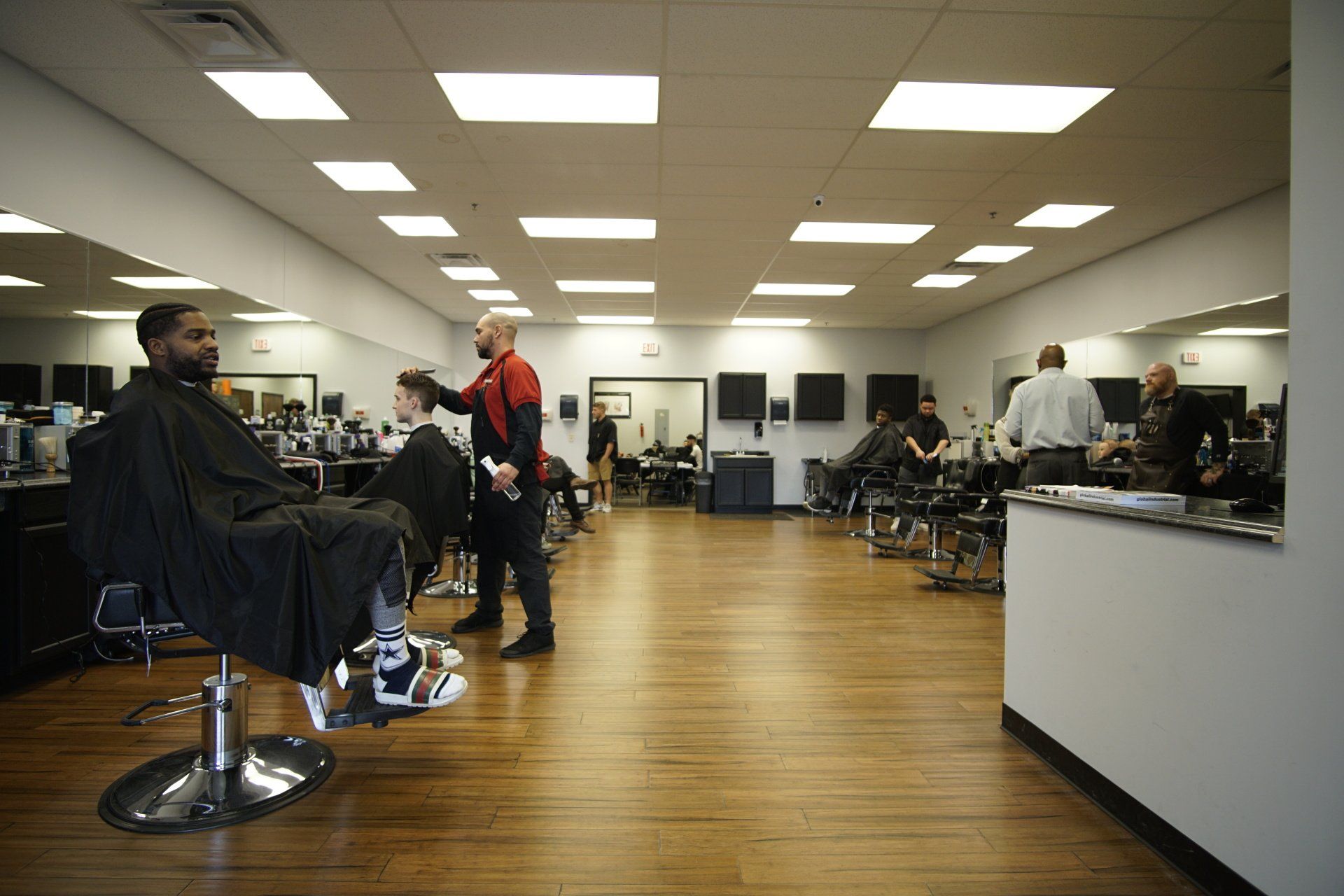 A man is getting his hair cut at a barber shop.