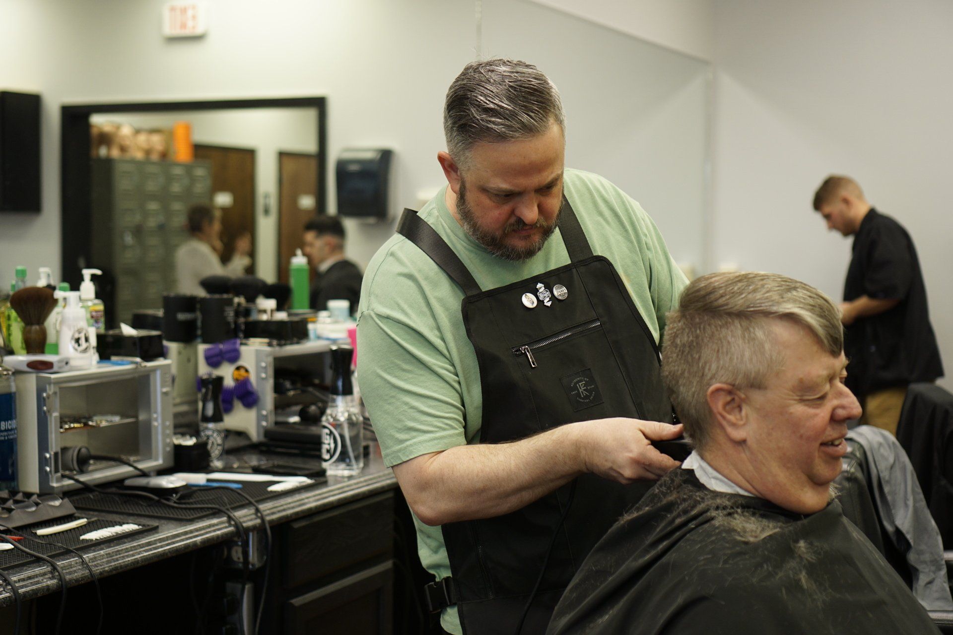 A man is getting his hair cut by a barber in a barber shop.