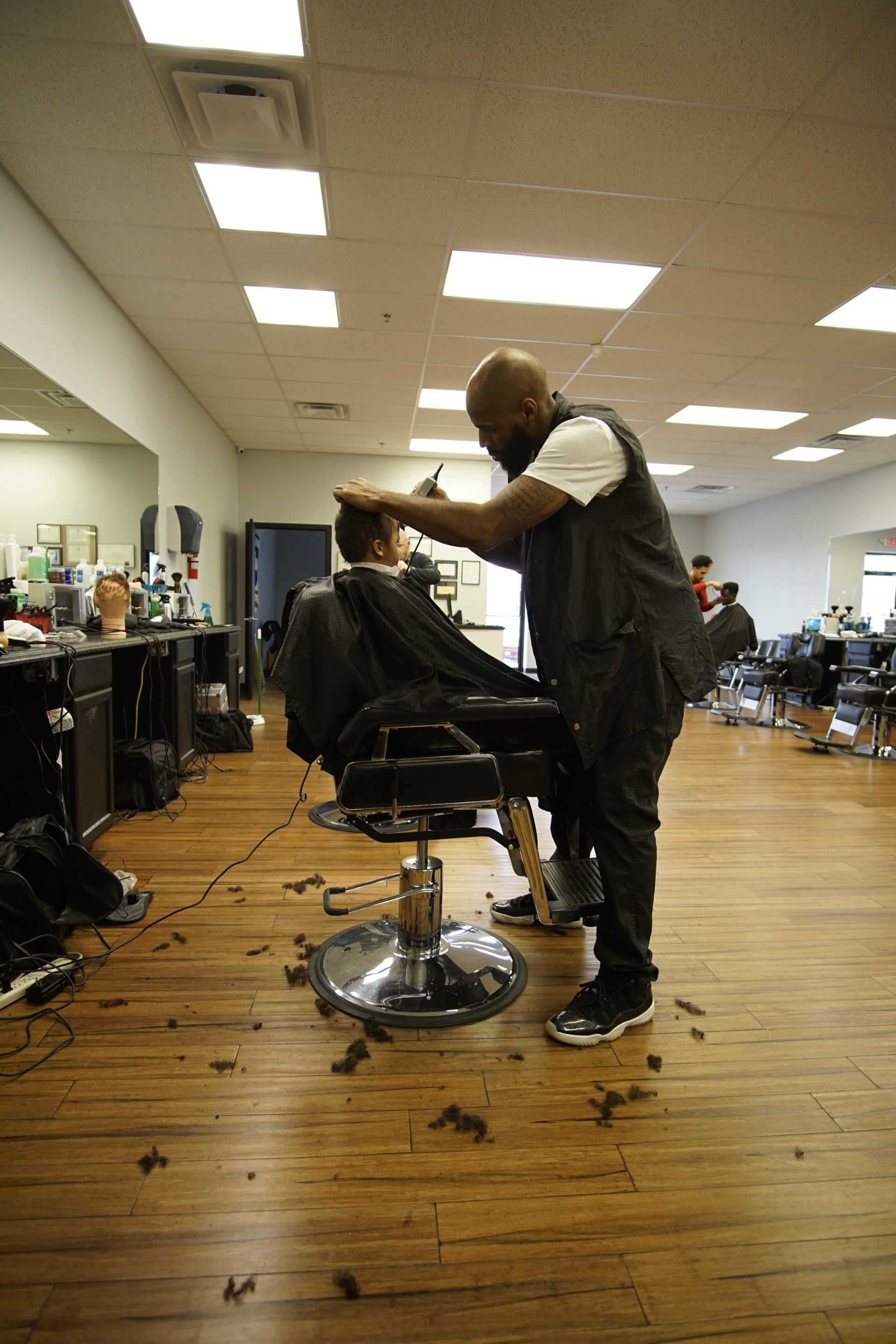 A man is getting his hair cut by a barber in a barber shop.
