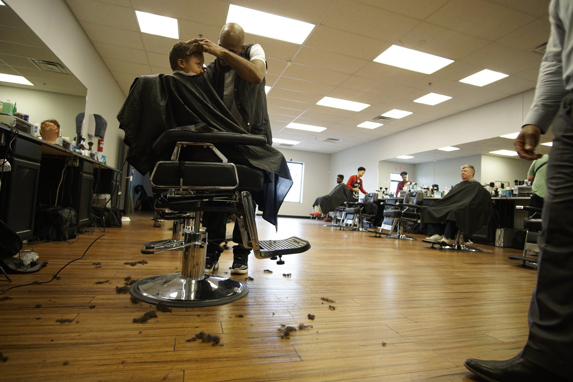 A man is getting his hair cut at a barber shop