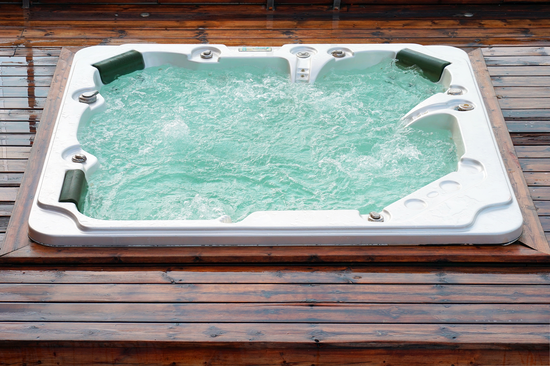 A hot tub is sitting on top of a wooden deck.