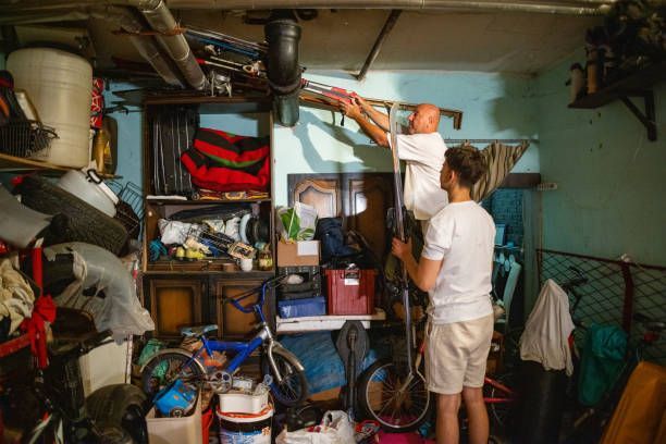 A man and a child are standing in a messy garage.