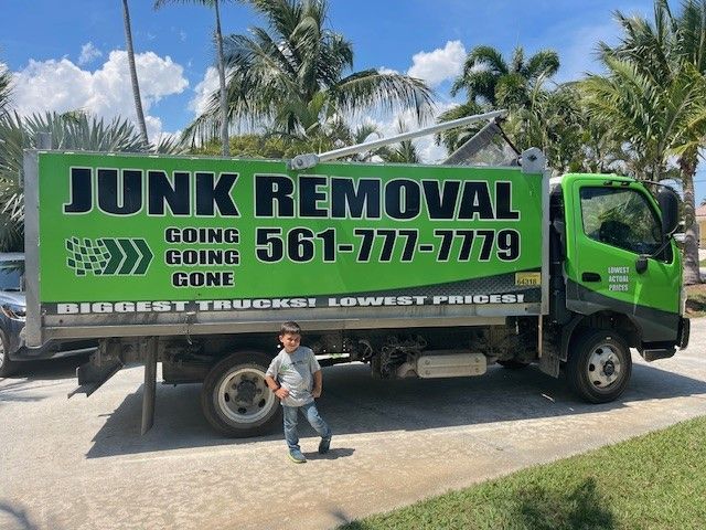 A man is loading a yellow trash can into a garbage truck.