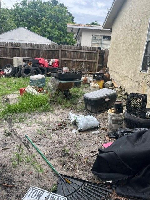 A backyard with a lot of trash and a license plate that says tow away