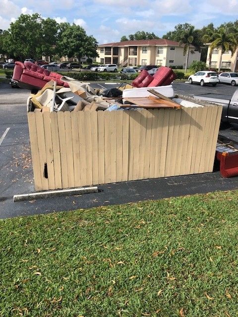 A backyard with a lot of trash and a license plate that says tow away