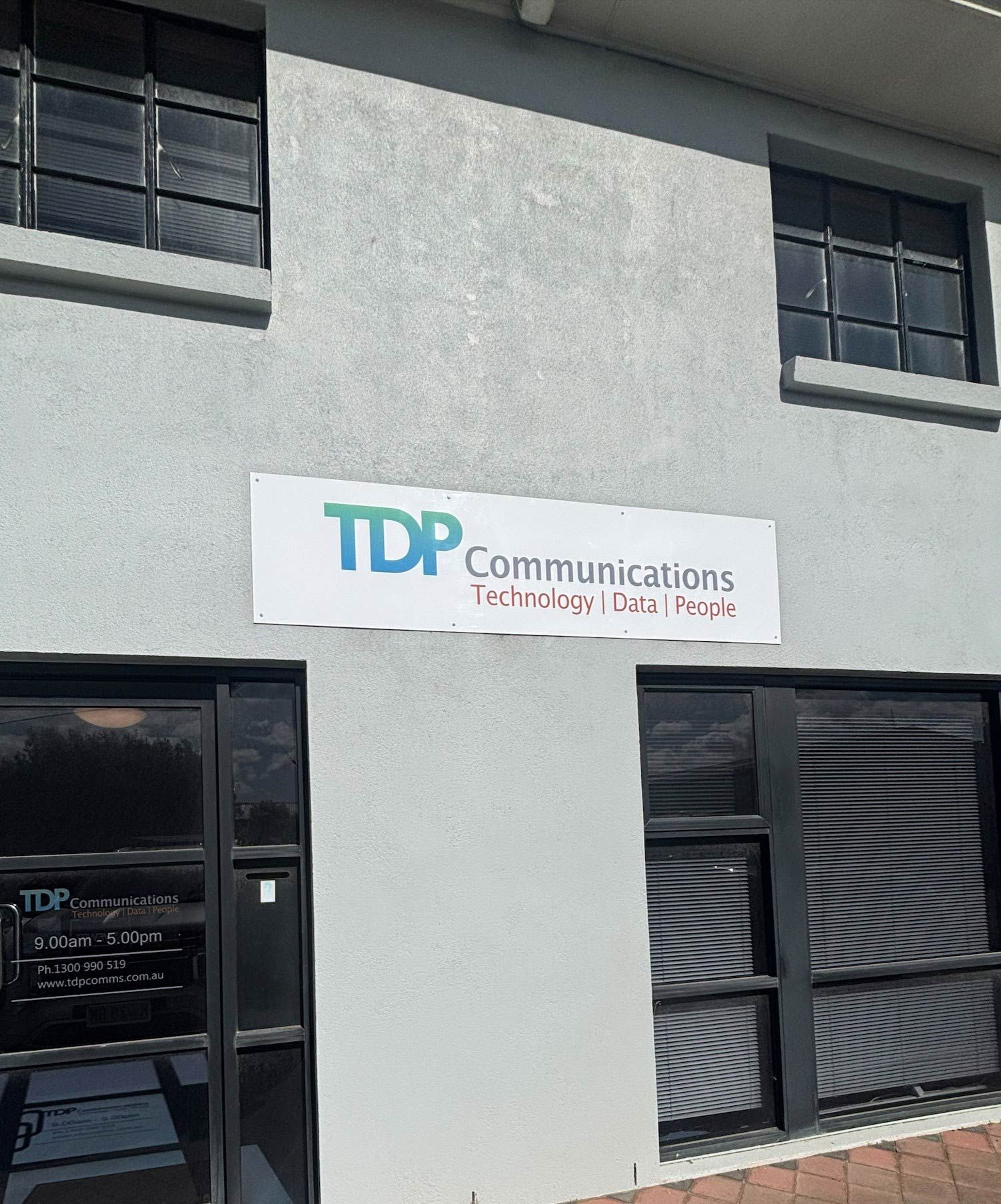 Exterior of a building with a TDP Communications sign: 