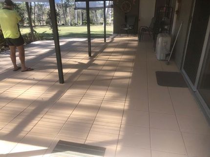 A Wooden Fence Surrounds a Concrete Walkway Next to a Gravel Driveway — Golden City Gympie Brick & Landscape in Gympie, QLD