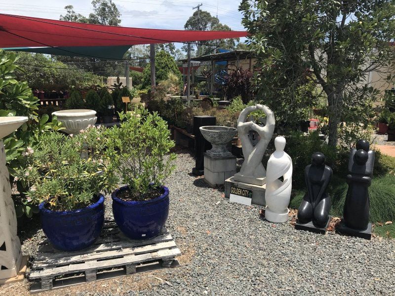 A Garden Filled With Lots of Potted Plants and Statues — Golden City Gympie Brick & Landscape in Gympie, QLD