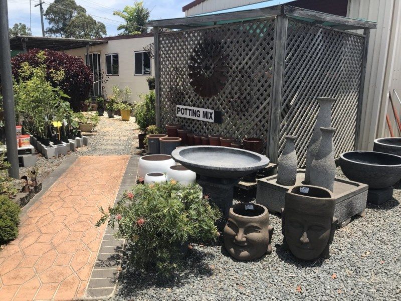 A Bunch of Pots and Vases Are Sitting in Front of a Building — Golden City Gympie Brick & Landscape in Gympie, QLD