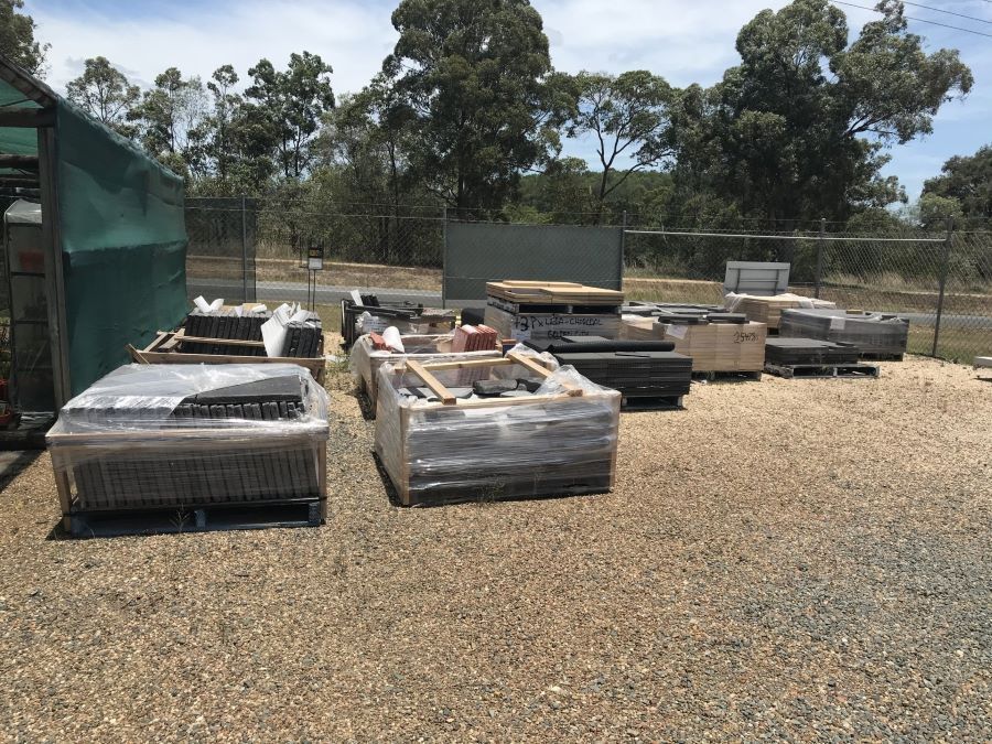 A Lot of Crates Are Sitting on the Ground in a Gravel Area — Golden City Gympie Brick & Landscape in Gympie, QLD