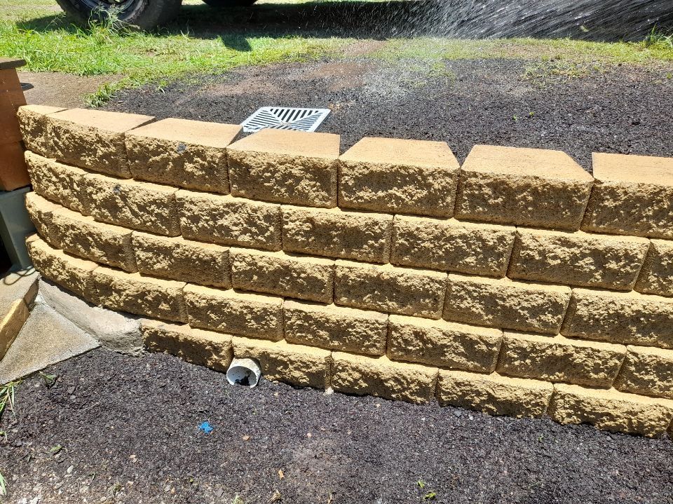 A Garden With Lots of Potted Plants and a Wooden Fence — Golden City Gympie Brick & Landscape in Gympie, QLD