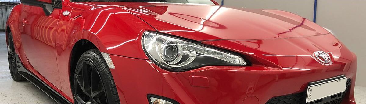 A Red Sports Car is Parked in a Garage — VIP Car Care Newcastle in Cardiff, NSW