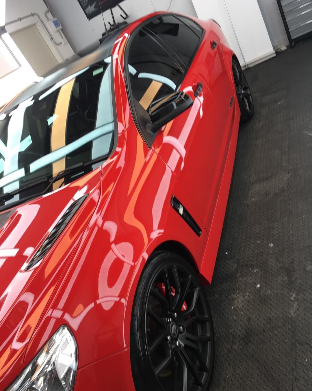 A Red Car With Black Wheels is Parked in a Garage — VIP Car Care Newcastle in Hunter Valley, NSW