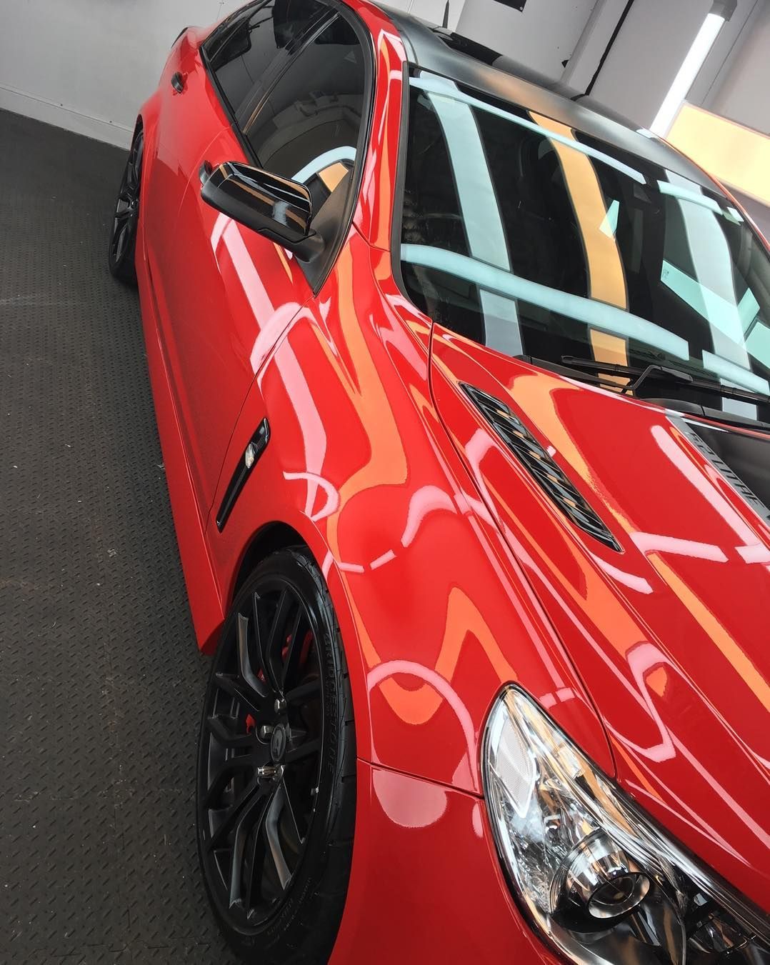 A Red Car With Black Wheels is Parked in a Garage — VIP Car Care Newcastle in Newcastle, NSW