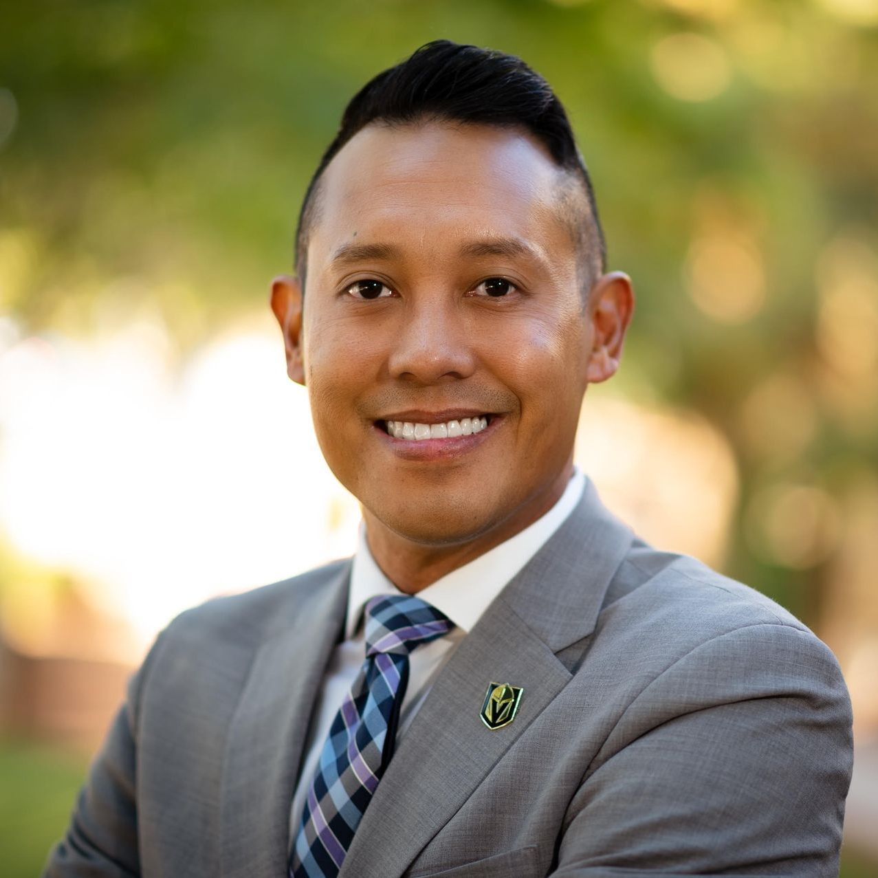 A man in a suit and tie is smiling for the camera.