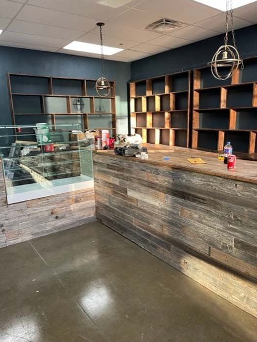 An empty store with a wooden counter and shelves.