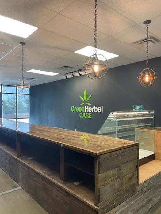 A store with a wooden counter and a sign that says green herbal care.