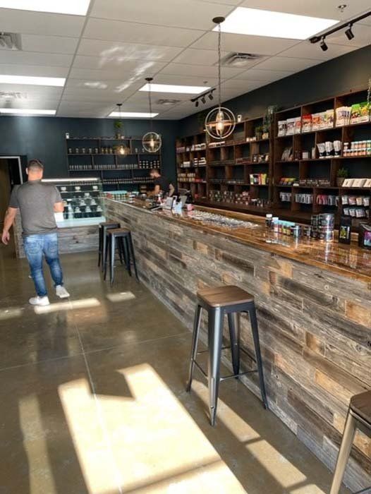 A man is walking past a long wooden counter in a store.