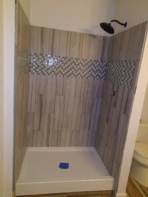 A bathroom with a shower stall and a shower head.