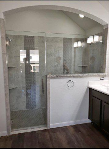 A bathroom with a sliding glass shower door and a sink.