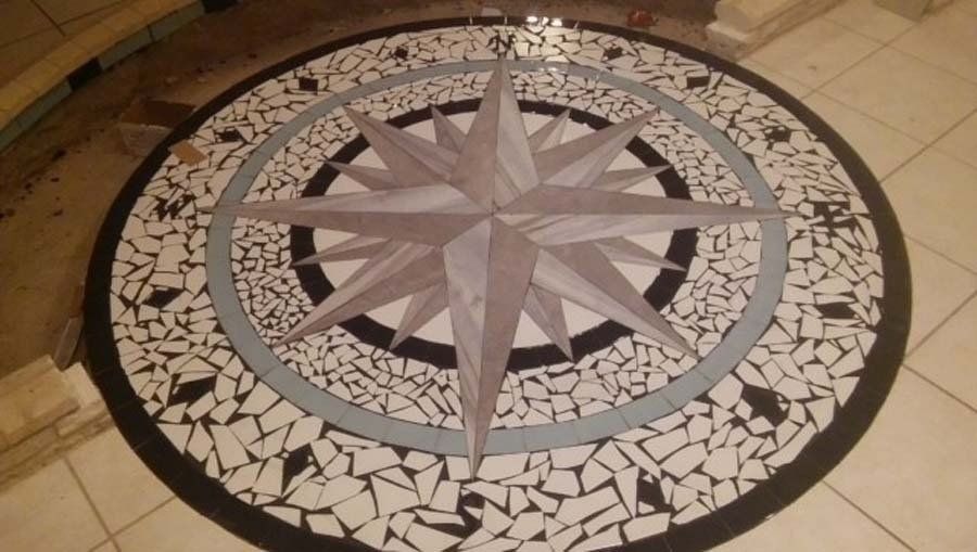 A mosaic of a compass on a tiled floor
