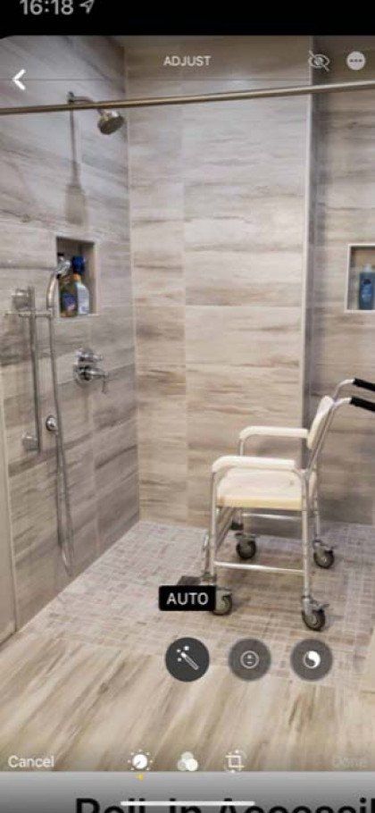 A bathroom with a shower and a chair in it.