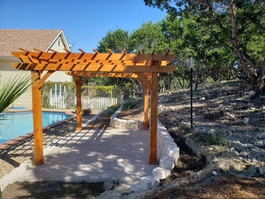 A wooden pergola is sitting next to a swimming pool