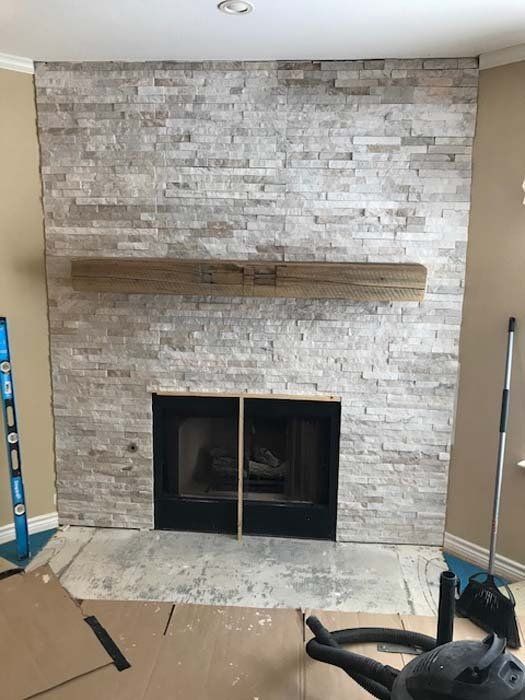 A living room with a fireplace and a vacuum cleaner.