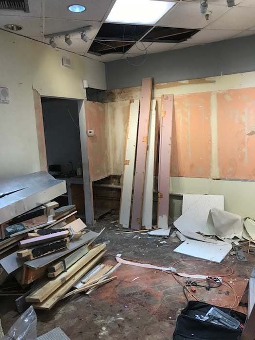 A room with a lot of wood on the floor and a ceiling that is missing.