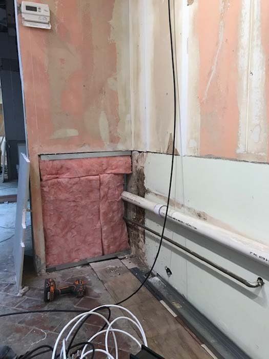 A room with a drill and a bunch of wires hanging from the wall.