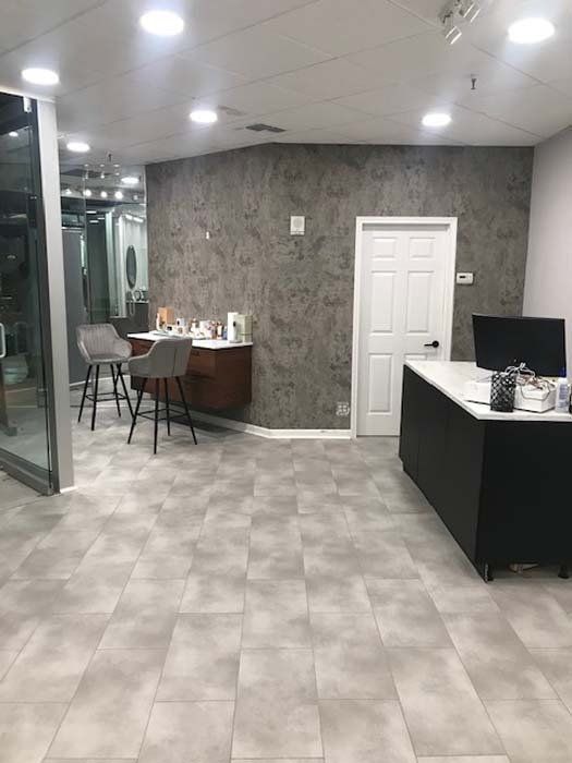 A large room with a tiled floor and a desk.