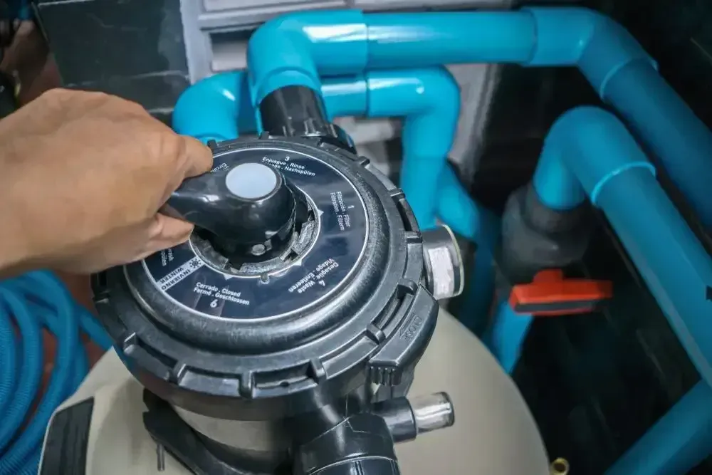 A Hand Adjusts the Multi-port Valve Handle on a Residential Swimming Pool — Sun Cool Pools & Spas in Hervey Bay, QLD