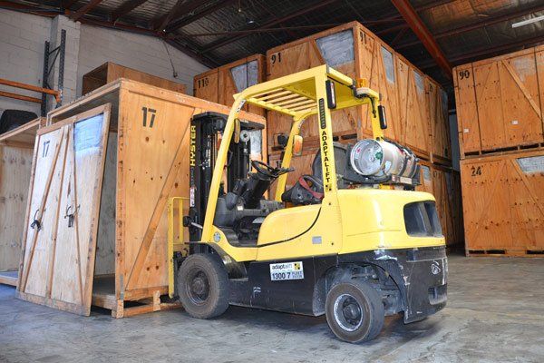 forklift lifting large shipping box