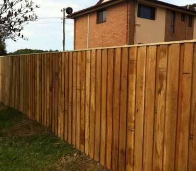 woman in garden next to fence done by a professional fence installer