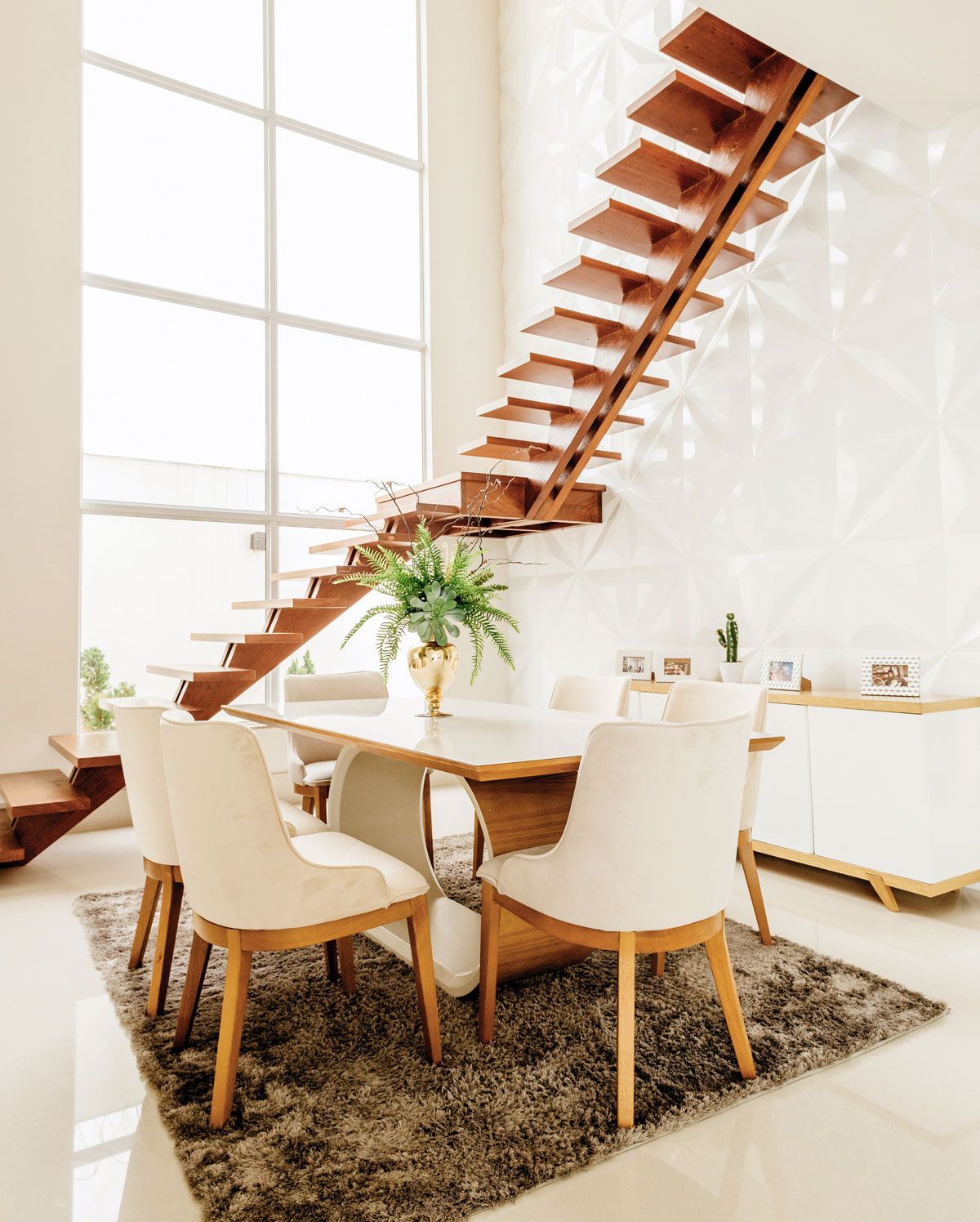 A home decorating project featuring a dining room with a table and chairs and a wooden staircase .