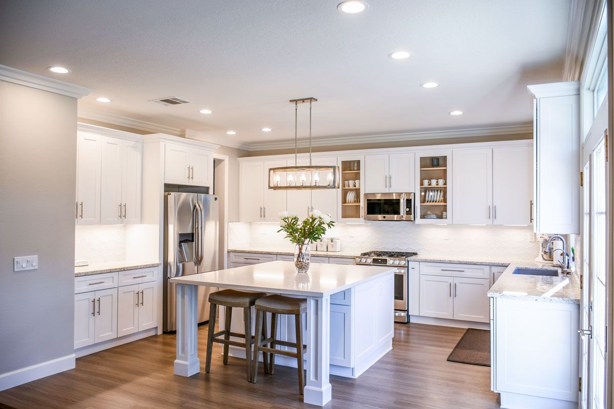 a kitchen with white cabinets , stainless steel appliances , and a large island interior decorating in Springfield, MA
