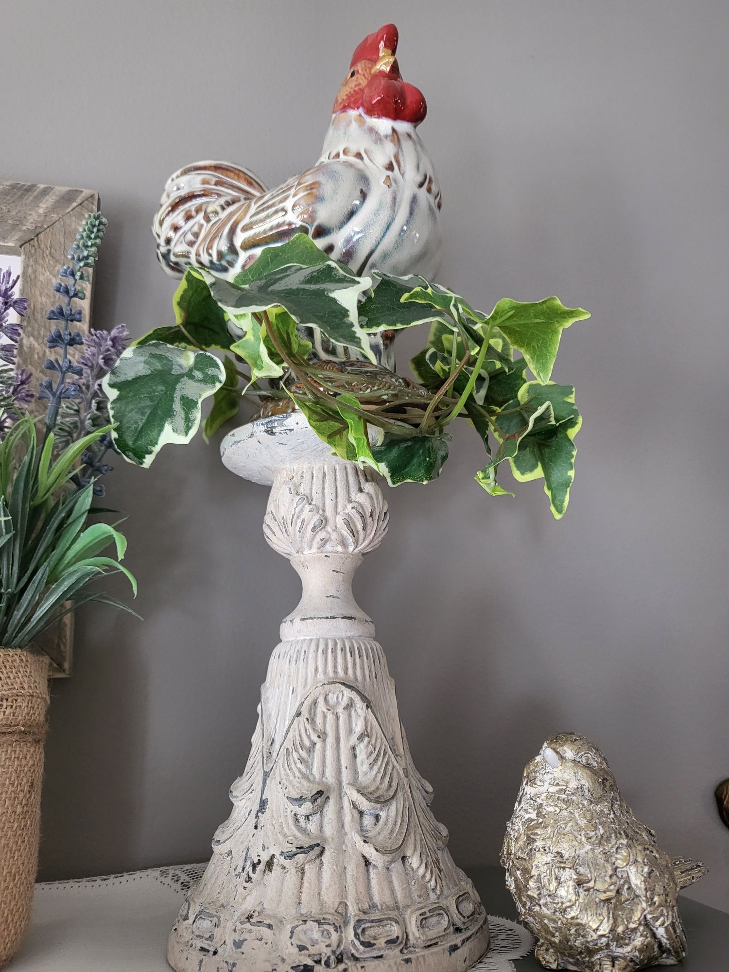 a statue of a rooster sitting on top of a vase .