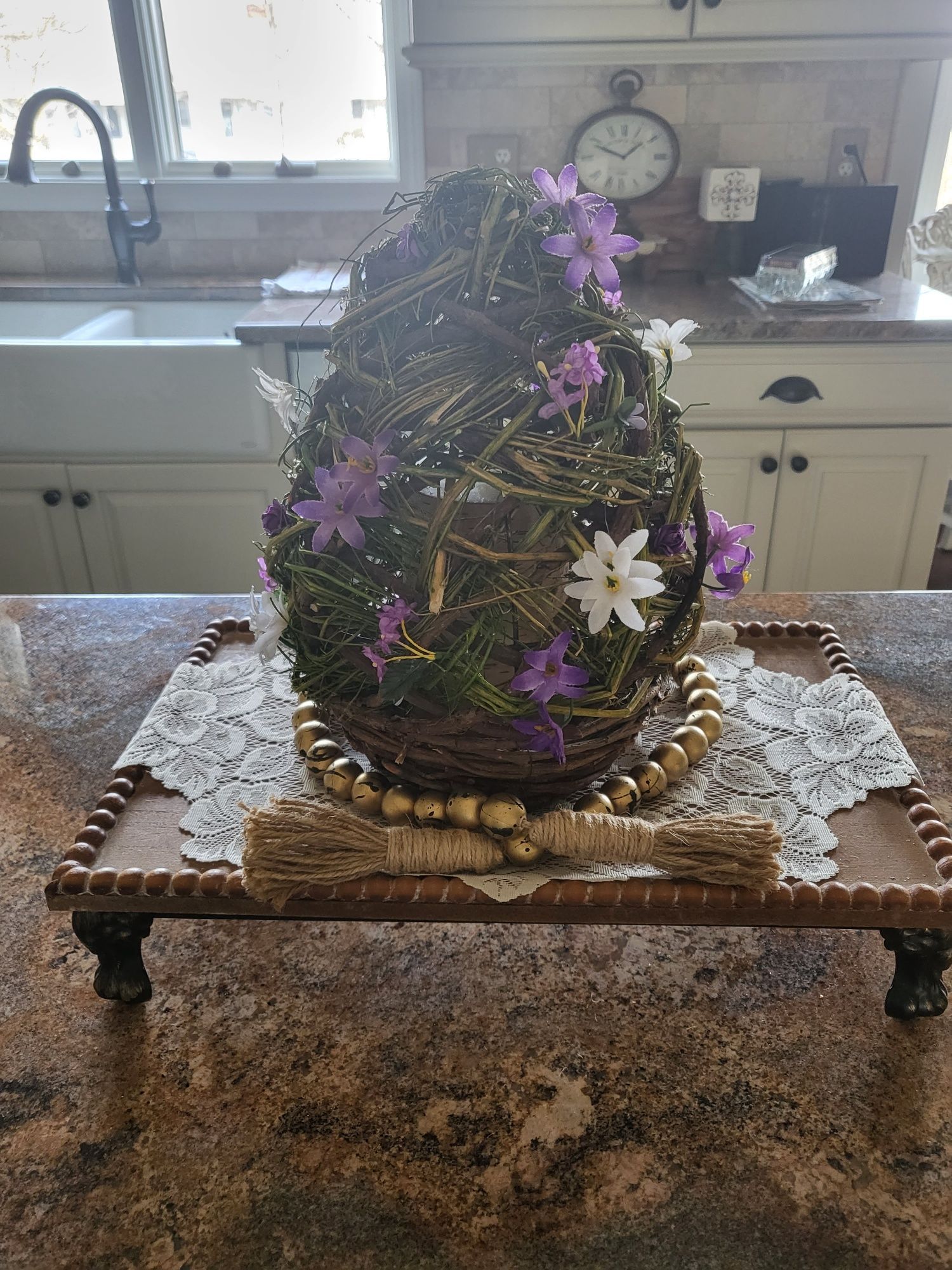 a wicker egg decorated with flowers is sitting on a wooden table riser - interior designing tips.