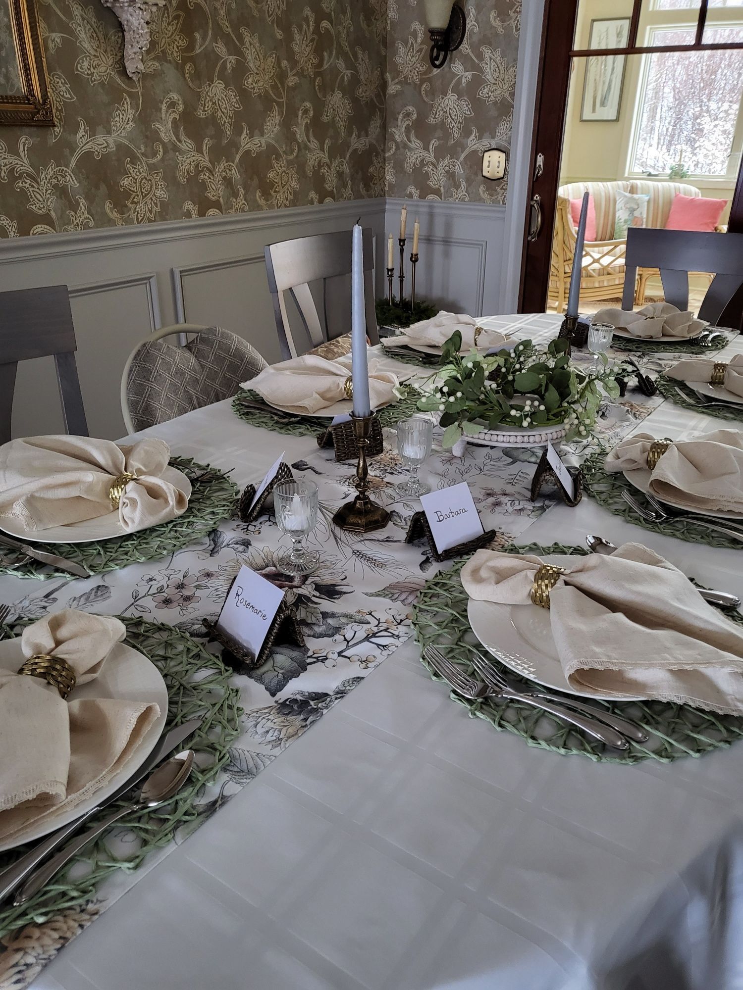a table set for a dinner party with plates , napkins , and candles .
