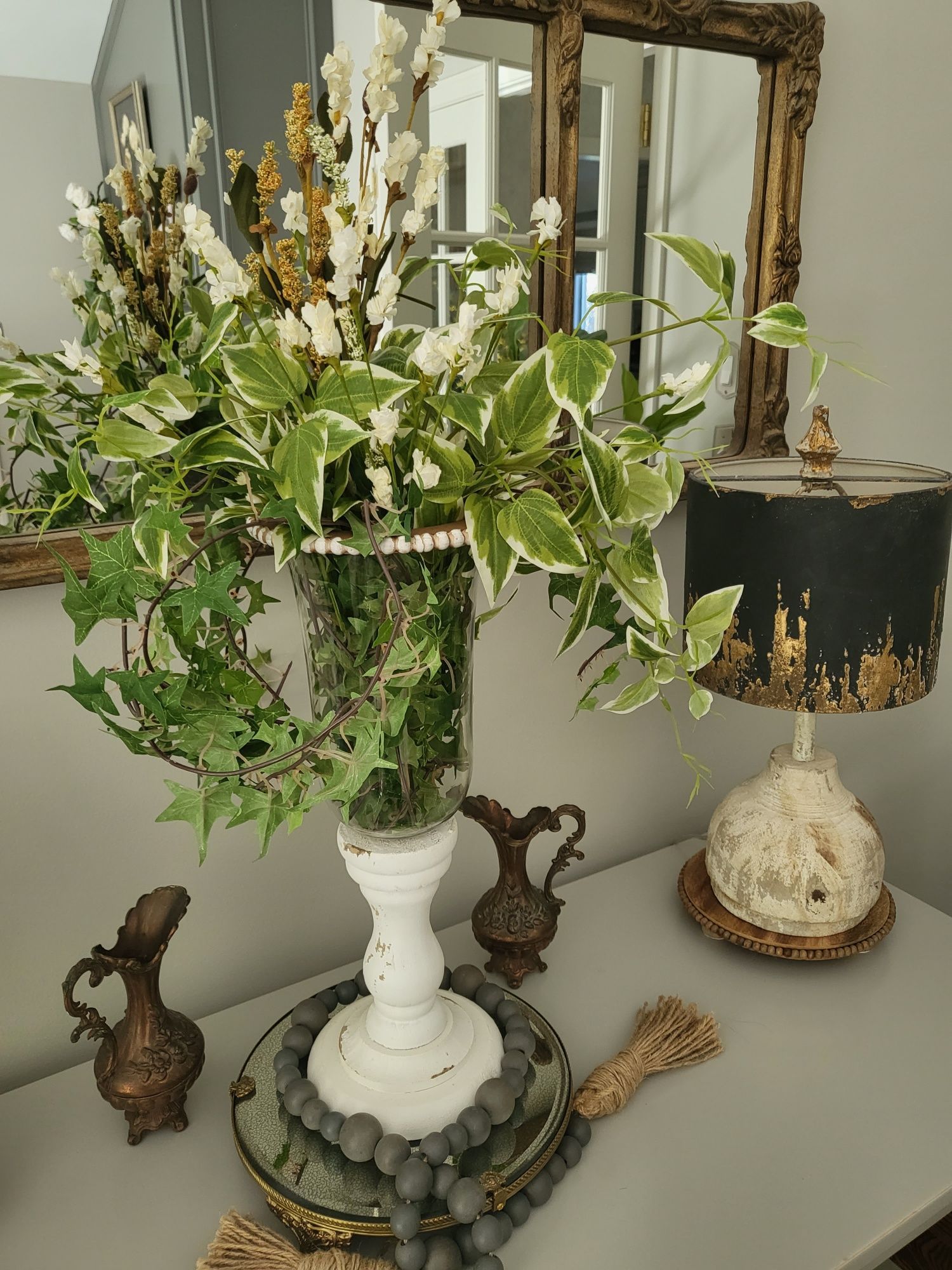 a table with a vase of flowers and a lamp on it .