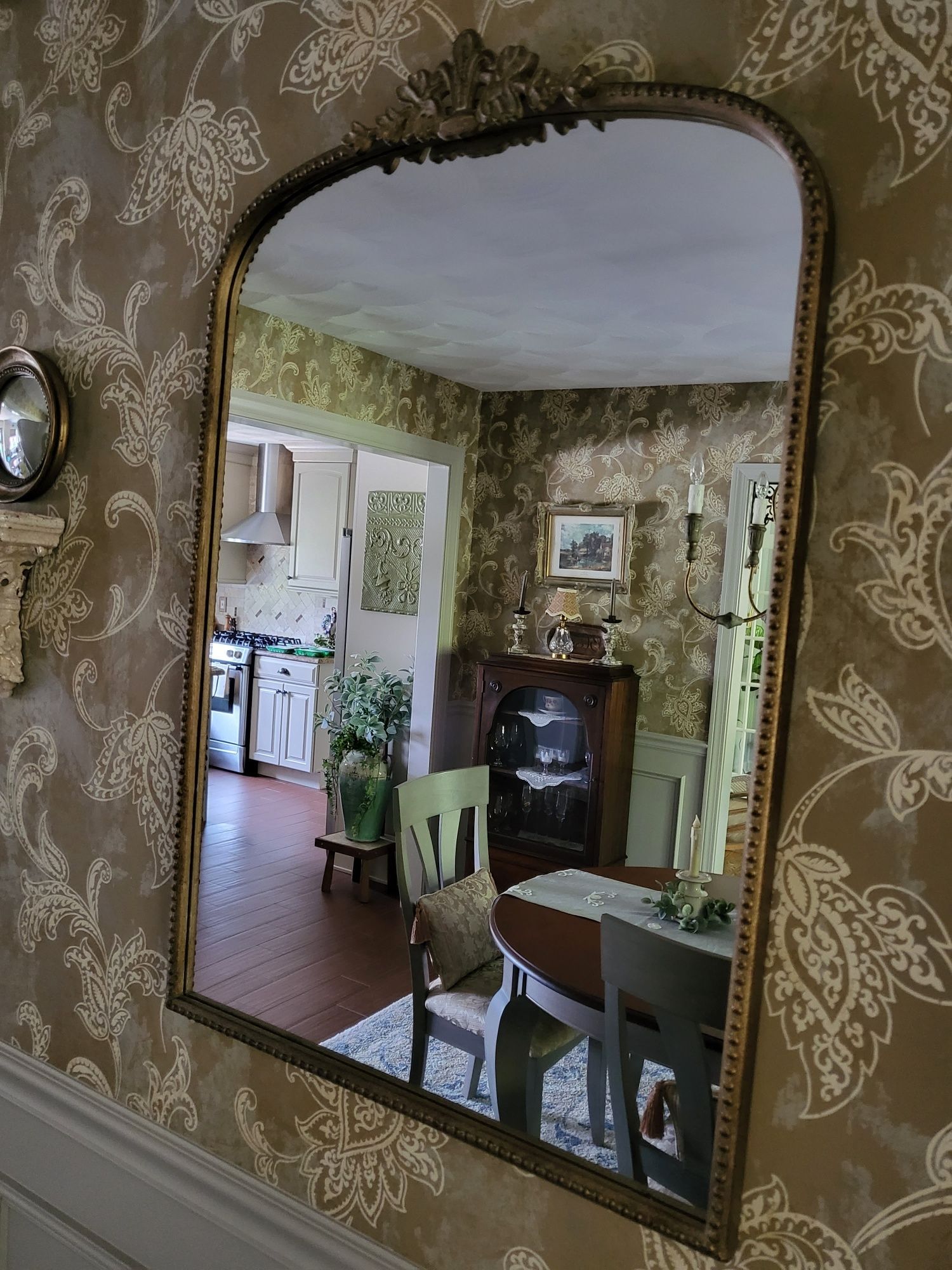 a large mirror is hanging on a wall in a dining room. Interior decorating example in Springfield, MA