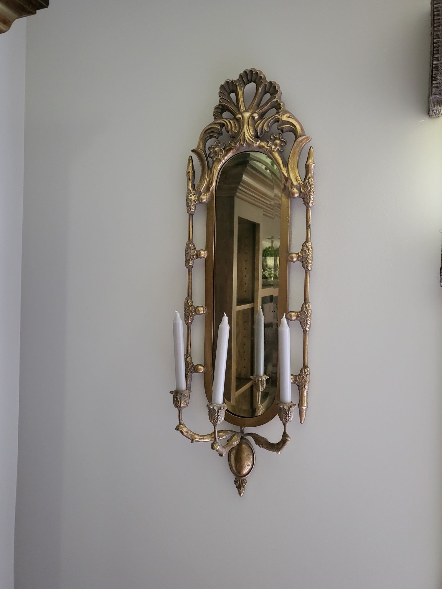 a mirror with candles hanging from it on a wall