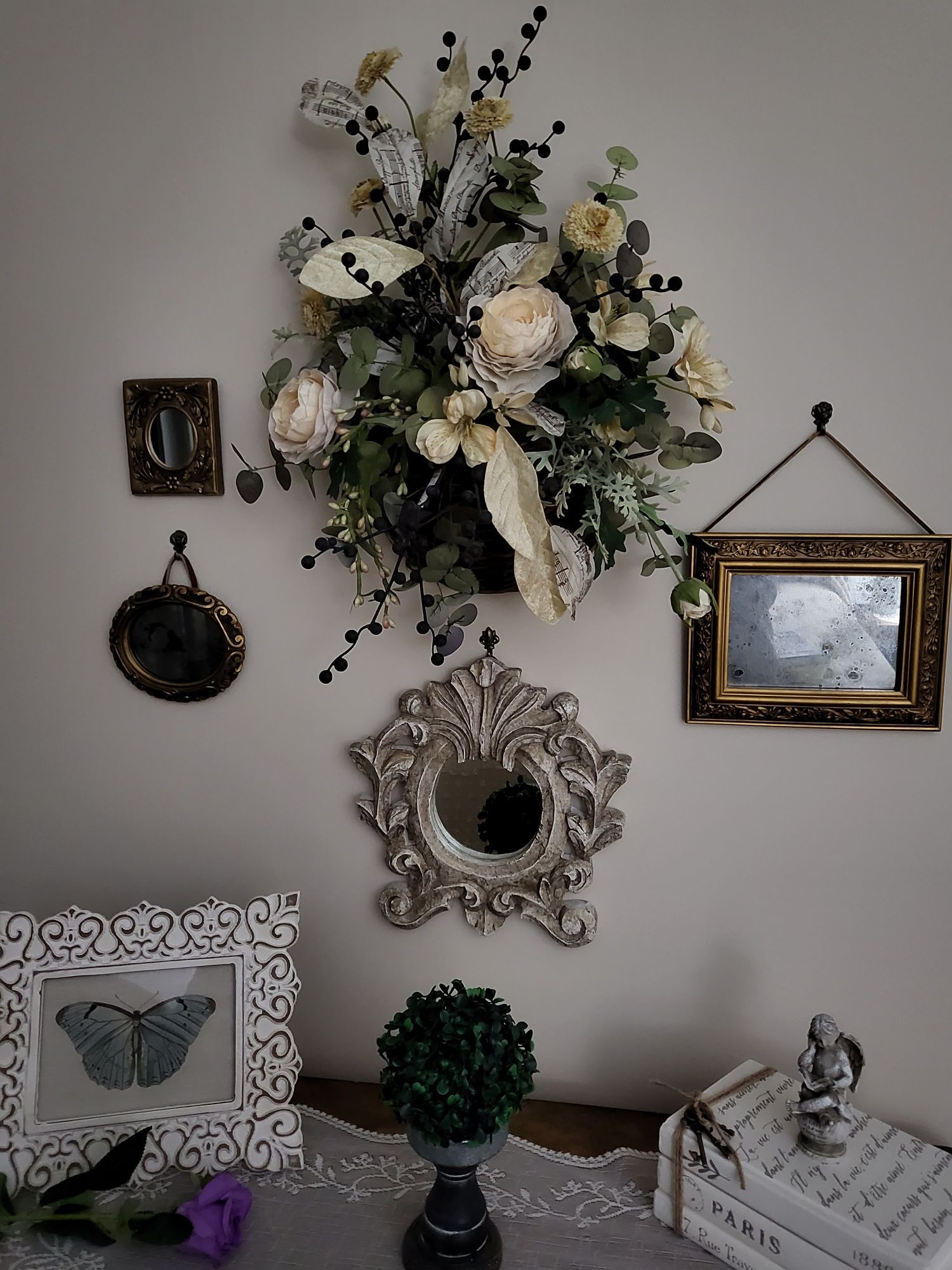 home decorating ideas showing a wall with numerous items hanging, including flowers, mirrors, and more.