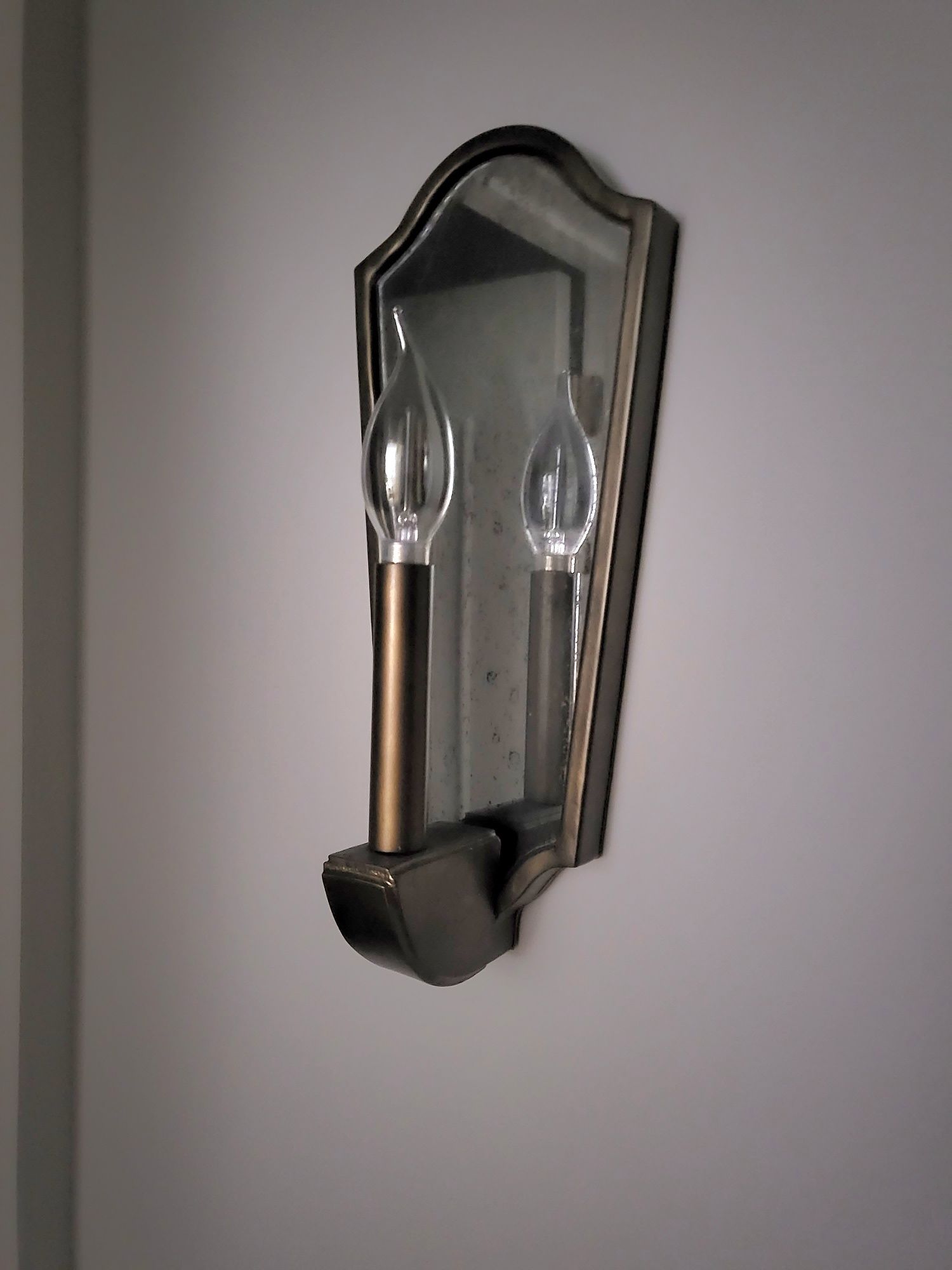 a wall light that looks like a face with two lights on it