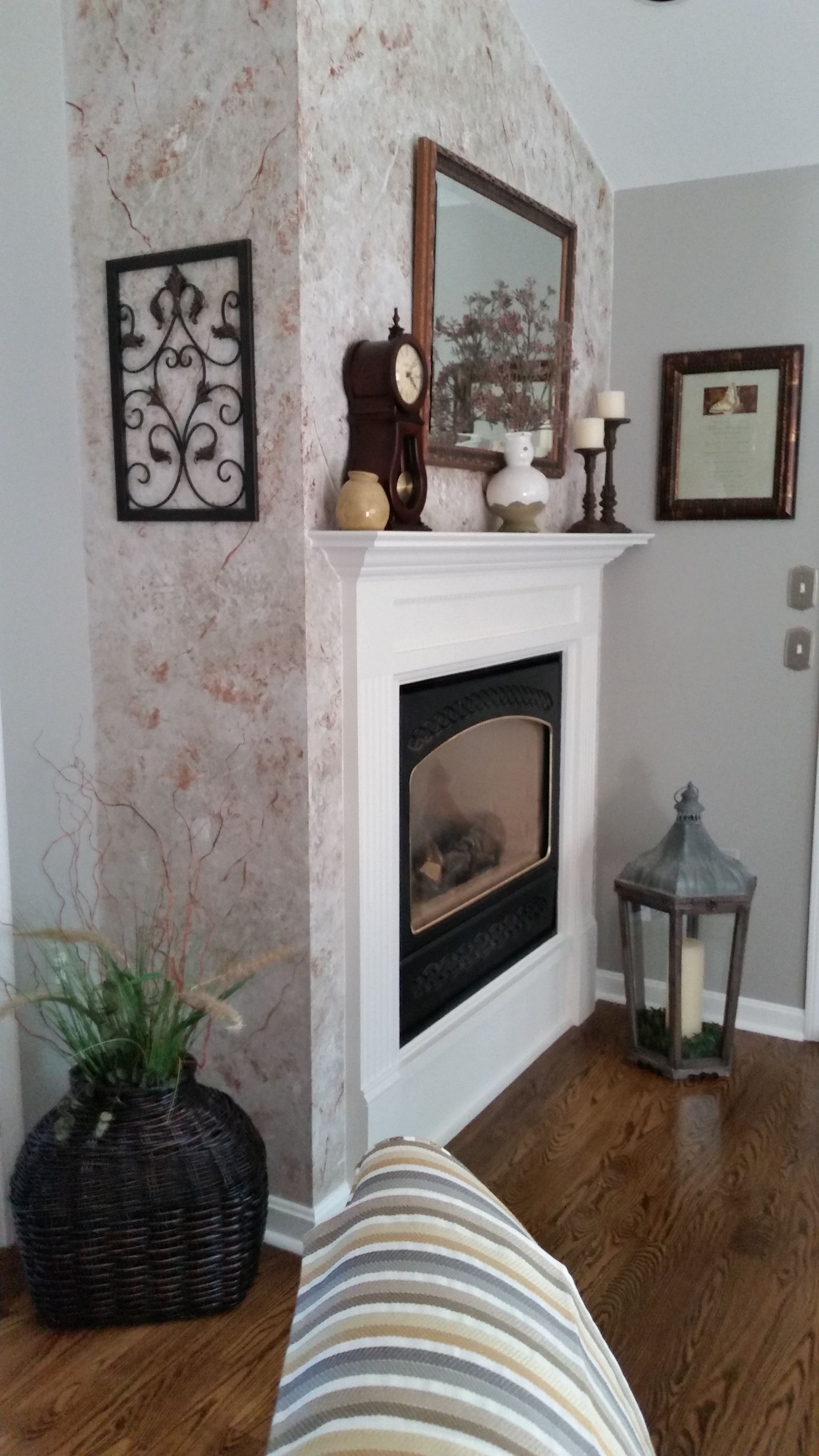 a living room with a fireplace and a clock on the mantle. Old fireplace design being updated by Casual Elegance Decor in Springfield, MA