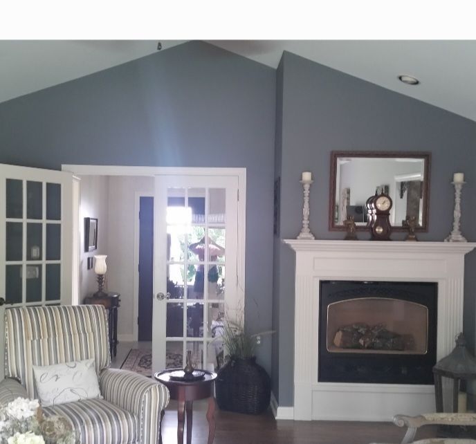 a living room with a vaulted ceiling and a fireplace. Interior designer project in Springfield being updated.
